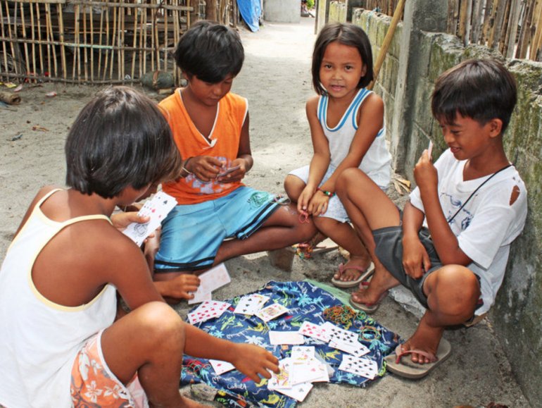 дети играющий на деньги под забором на улице